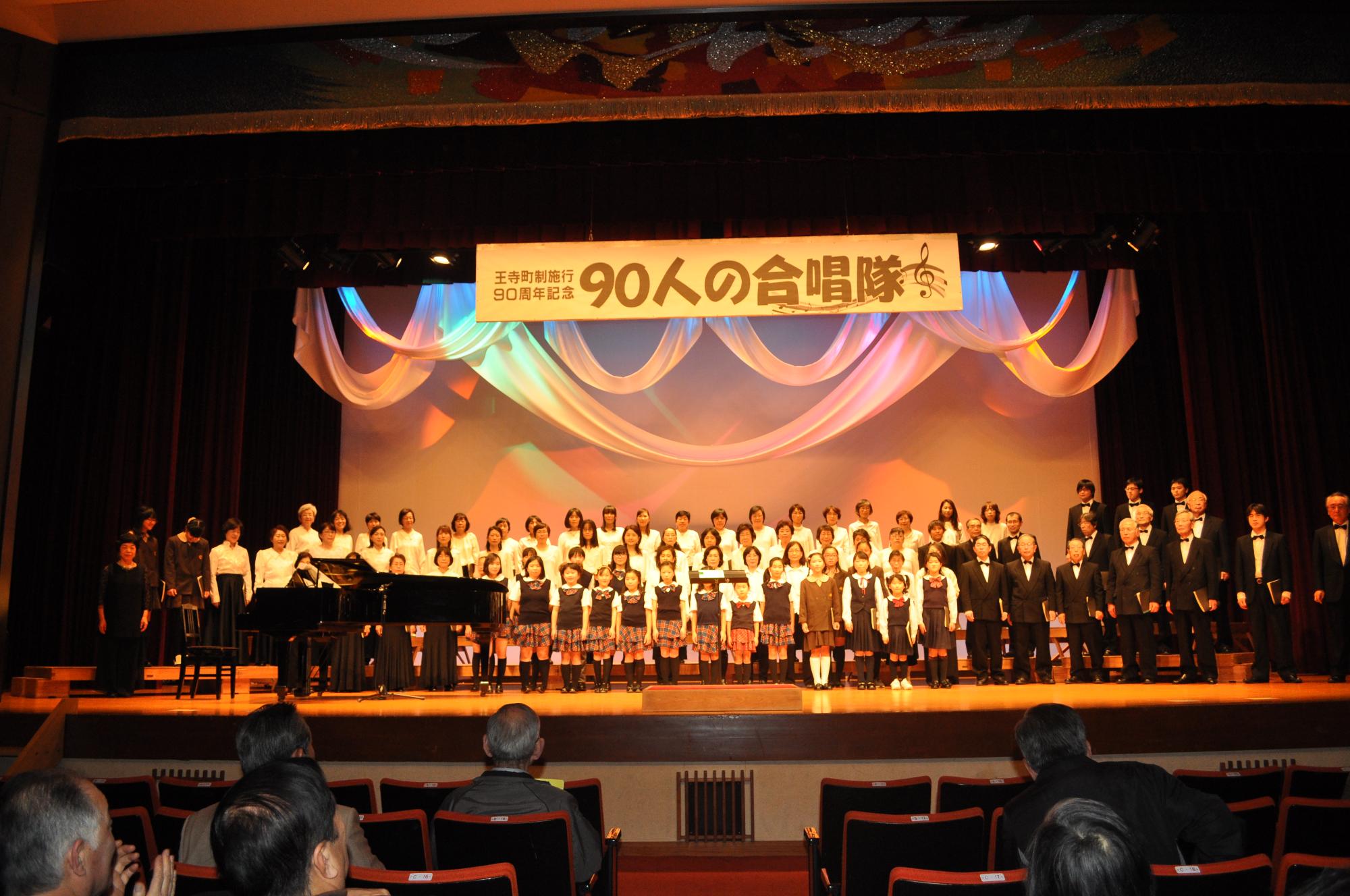 90人の合唱隊が歌っている
